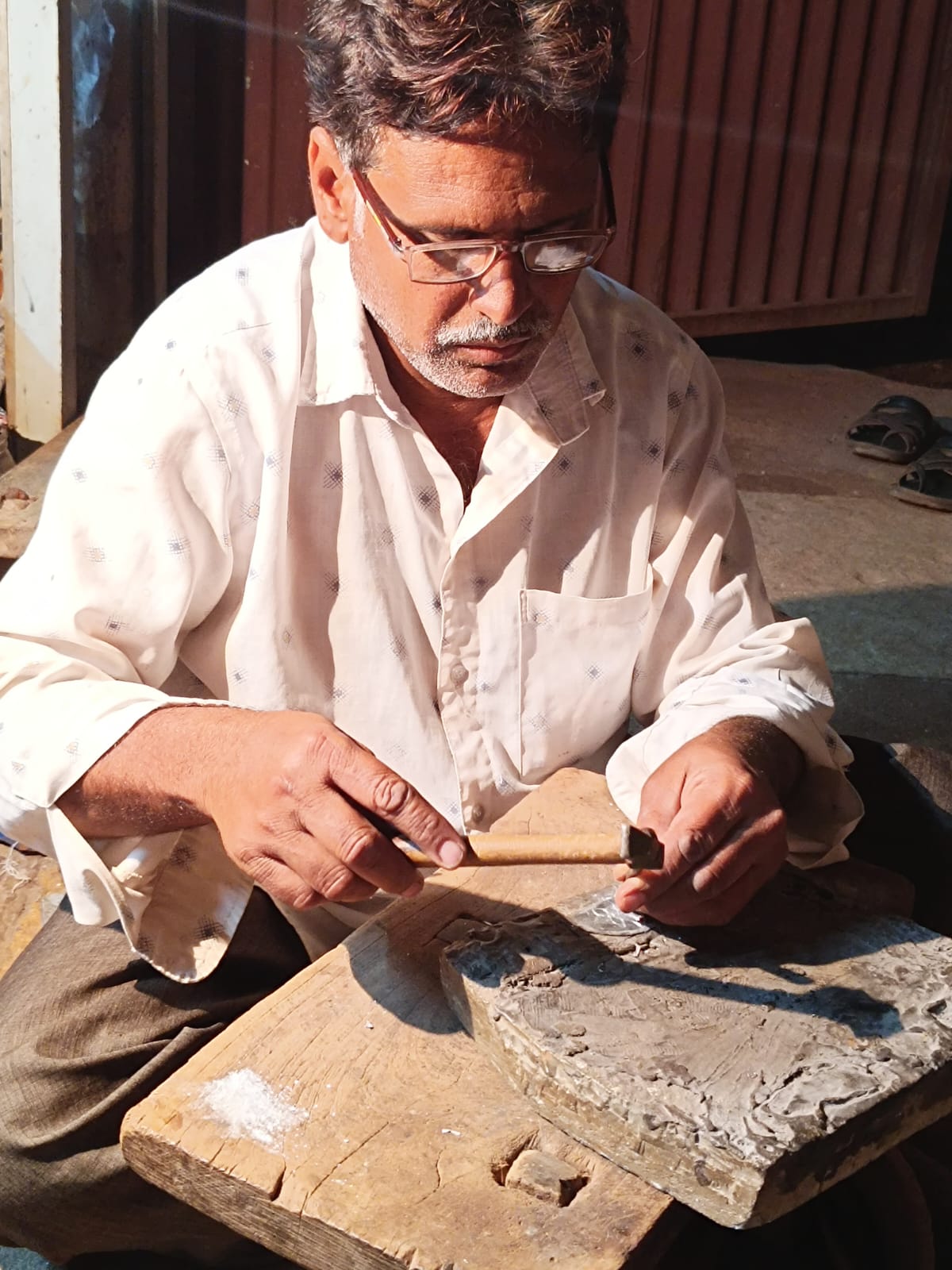 An artisan working on the Bidri Logo