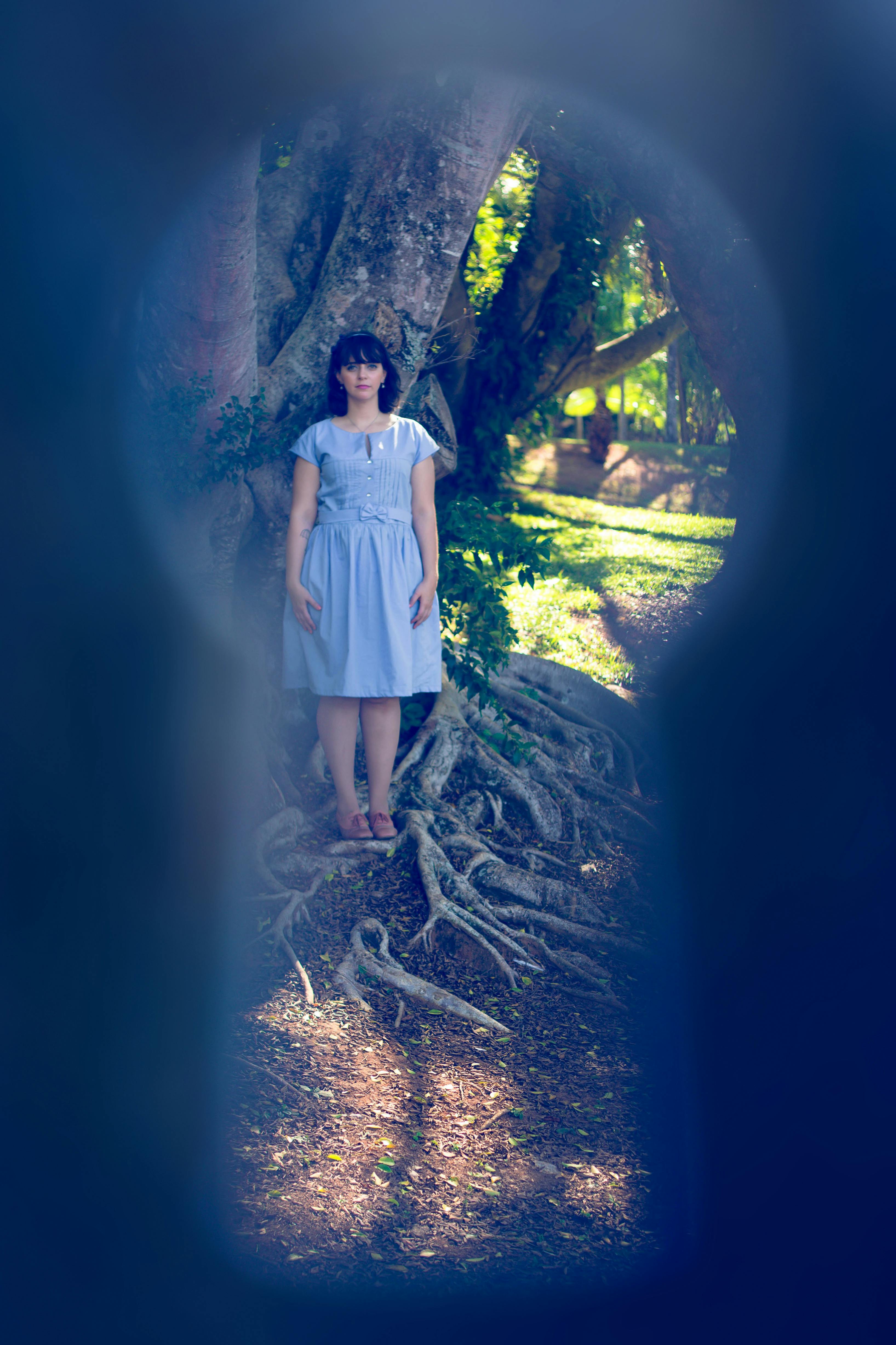 Photo by Naele Souza: https://www.pexels.com/photo/woman-standing-by-the-tree-photographed-through-a-keyhole-12753709/